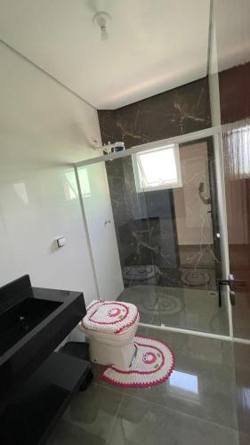 a bathroom with a toilet and a glass shower at Cantinho aconchego gc in Ubatuba
