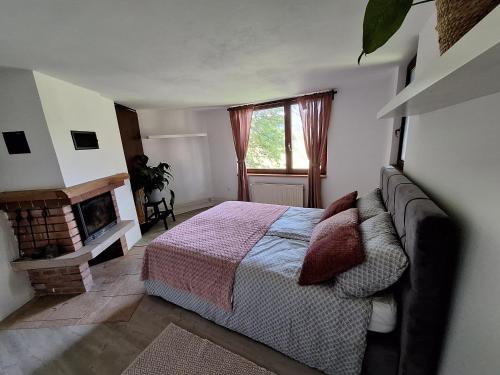 a bedroom with a bed and a fireplace at Hiška na skalci, The House on the Rock in Krka