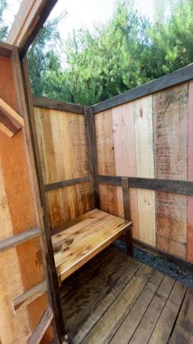 a wooden bench sitting on a wooden deck at Forest Bunkie Trails & Stargazing in Simcoe