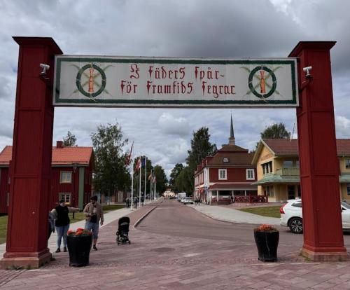 a sign for a town with people walking down a street at Målkullorna Hostel in Mora