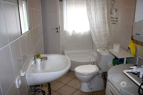 a white bathroom with a sink and a toilet at One-Bedroom Apartment in Putbus I in Putbus