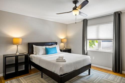 a bedroom with a bed with a ceiling fan and a window at Brookwood Courtyard by BCA Furnished Apartments in Atlanta