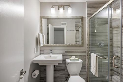 a bathroom with a sink and a toilet and a mirror at Brookwood Courtyard by BCA Furnished Apartments in Atlanta