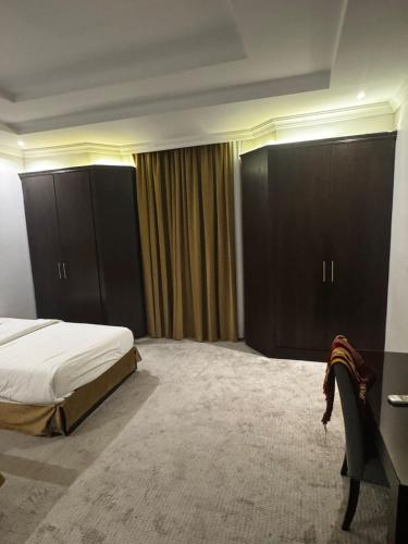 a bedroom with a bed and some brown cabinets at ذا جولد للشقق المخدومة in Jeddah