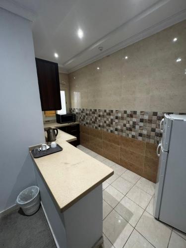 a kitchen with a refrigerator and a counter top at ذا جولد للشقق المخدومة in Jeddah