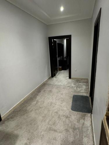 an empty room with white walls and a carpet at ذا جولد للشقق المخدومة in Jeddah