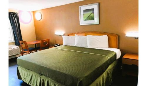a hotel room with a large bed and a table at OYO Hotel Tallahassee Downtown in Tallahassee