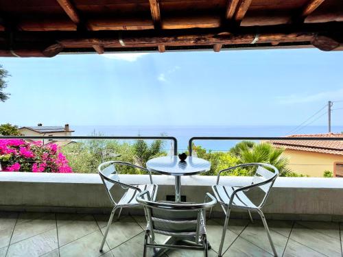 a table and chairs on a balcony with a view at Casa Trama in Pisciotta