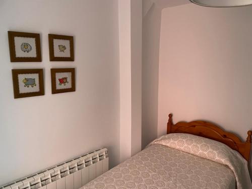 a bedroom with a bed and three pictures on the wall at Casa Ferrero Salvador in Bolea