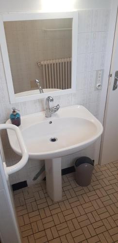 un lavabo blanc dans une salle de bain avec un miroir dans l'établissement Ty Denise, à La Celle-sous-Gouzon