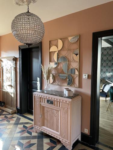 a room with a wooden cabinet and a chandelier at La Maison de Martha in Jaunay-Clan