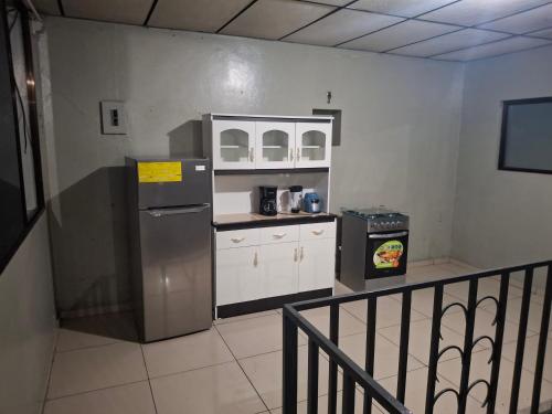 una cocina con refrigerador y encimera en Habitacion sencilla, en San Salvador