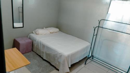Un pequeño dormitorio con una cama y una mesa. en Habitacion sencilla, en San Salvador
