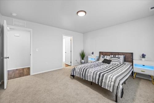 a bedroom with a bed with a striped comforter at Heart of Caldwell- HotTub-Fenced Yard- Spacious in Caldwell