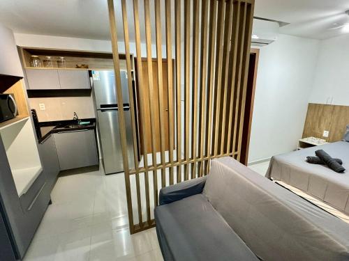 a living room with a couch and a kitchen at UNU 602 Itapuã: piscina, academia, praia e+ in Salvador