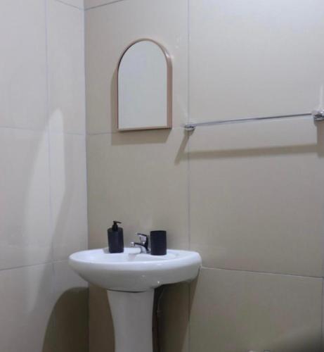 a white bathroom with a sink and a mirror at 54 River Logde in Mokopane