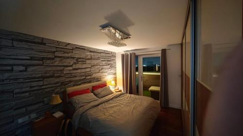 a bed in a room with a stone wall at The Bridge in Dartford