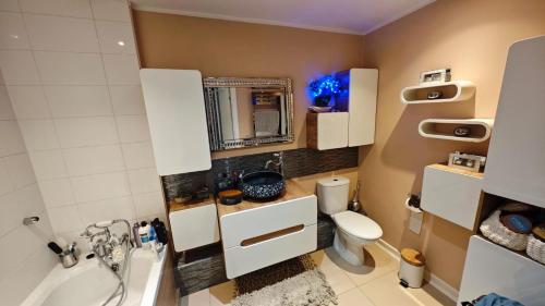 a bathroom with a sink toilet and a mirror at The Bridge in Dartford