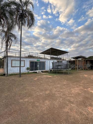 a white house with a palm tree and a building at Flat do Oscar na Villela Home Stay Lago Sul DF in Brasilia
