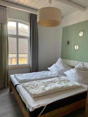 a bed in a bedroom with a large window at Ferienwohnung Rosenholz in Butjadingen