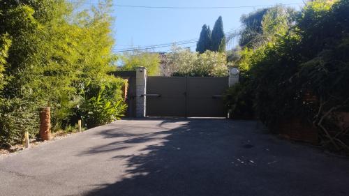a driveway leading to a garage with a gate at appartement 1 étoile paisible et son jardin privé in Les Adrets de l'Esterel