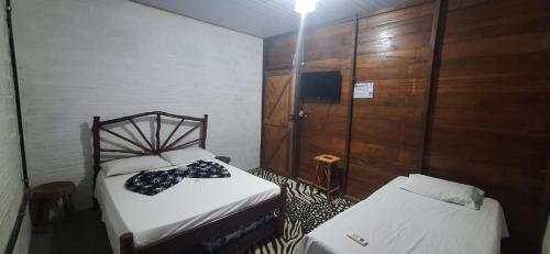 a small room with two beds and a tv at Espaço Sairé - 8 minutos da Praia in Alter do Chao