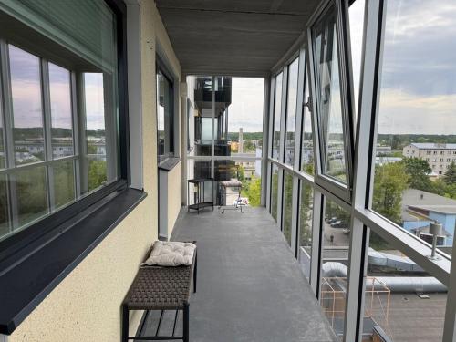 balcón de un edificio con banco y ventanas en Overnight in Haapsalu skyscraper!, en Haapsalu