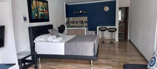 a bedroom with a bed and a blue wall at Hermoso aparta estudio in Zarzal