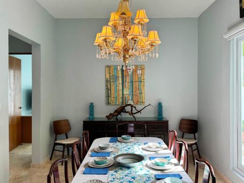 a dining room with a table and a chandelier at Condado Laguna Villa w Pool 5 Bd 3 Ba - Generator in San Juan