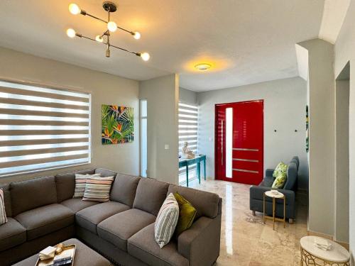 a living room with a couch and a red door at Condado Laguna Villa w Pool 5 Bd 3 Ba - Generator in San Juan