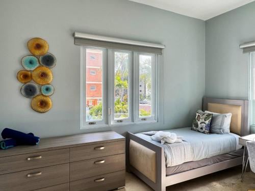 a bedroom with a bed and a dresser and two windows at Condado Laguna Villa w Pool 5 Bd 3 Ba - Generator in San Juan