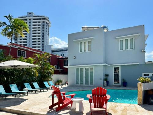 a building with chairs and a swimming pool at Condado Laguna Villa w Pool 5 Bd 3 Ba - Generator in San Juan