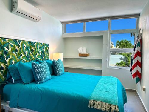 a bedroom with a blue bed and a window at Condado Laguna Villa 1 - Spa - 6 Bd 3Ba Generator in San Juan