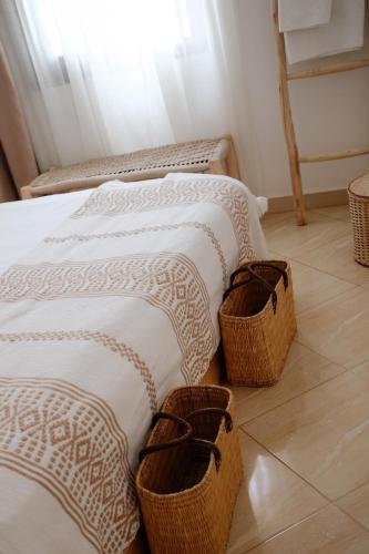 two beds in a room with baskets on the floor at Riad Searenity in Tamraght Ouzdar