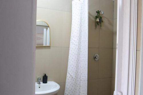 a bathroom with a shower curtain and a sink at 54 River Logde in Mokopane