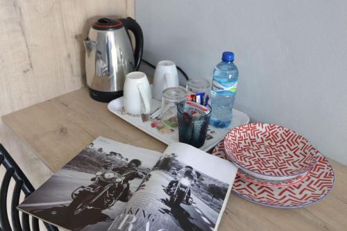 a table with a tea kettle and a book on it at 54 River Logde in Mokopane