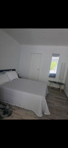 a bedroom with a white bed and a window at Danny's Rural Suite T1 in Curral das Freiras