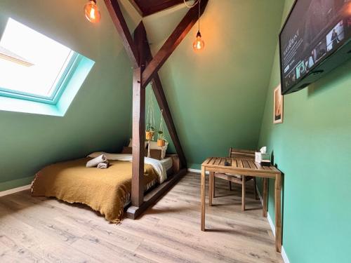 a bedroom with a bed and a tv and a table at Cabane urbaine in Sarreguemines