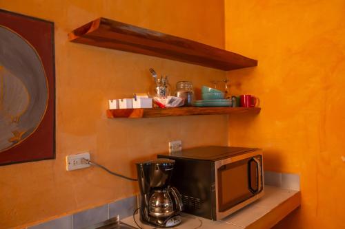 a microwave sitting on top of a shelf next to a kitchen at Lake Arenal Hotel & Brewery in Tilarán