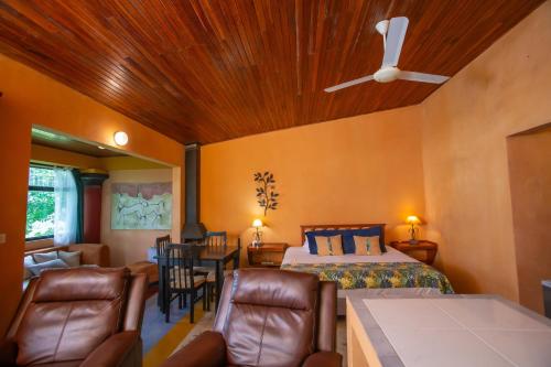 a bedroom with a bed and a table and chairs at Lake Arenal Hotel & Brewery in Tilarán
