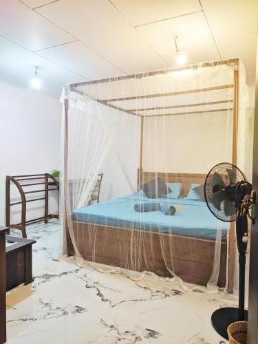 a bedroom with a bed with a canopy at Moon Bay in Mirissa