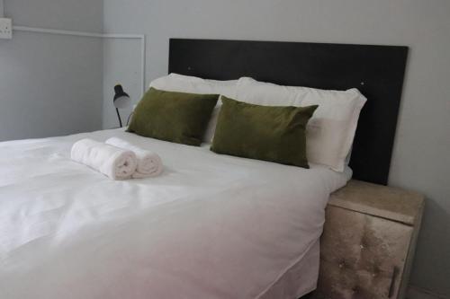 a white bed with two rolls of towels on it at 54 River Logde in Mokopane