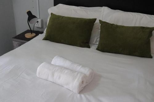 a white towel on top of a white bed at 54 River Logde in Mokopane