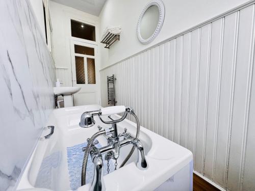a white bathroom with a sink and a tub at THE RESTING LION - Gourock Town Center Holiday Home Apartment in Gourock