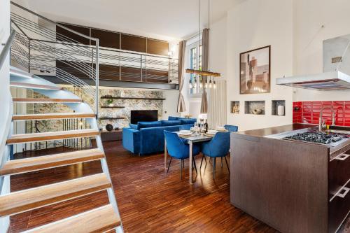 a kitchen and living room with a table and blue chairs at Milano Wellness Suite - Spa, Sauna & Gym Experience in Milan