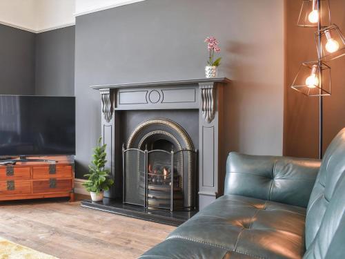 a living room with a fireplace and a couch at Ty Isaf in Barmouth