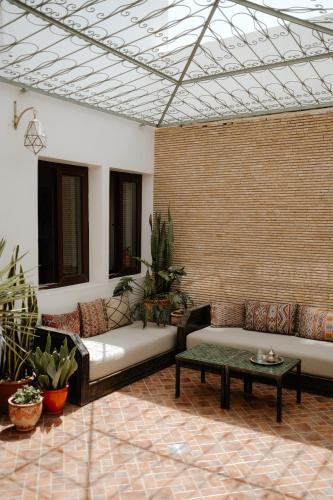 a living room with couches and a brick wall at Riad Searenity in Tamraght Ouzdar