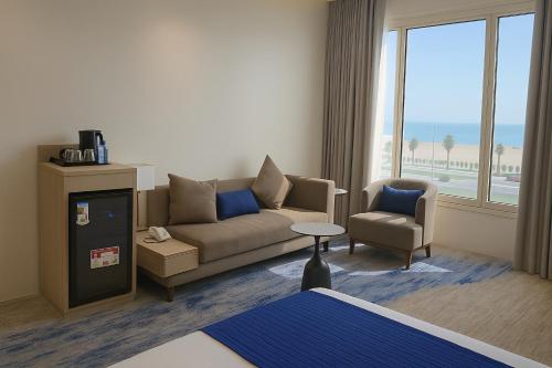 a living room with a couch and a chair at Elite Served Apartments - Al Cornich in Jeddah