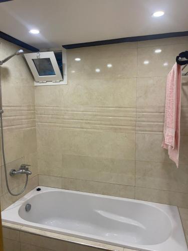 a bath tub in a bathroom with a pink towel at Al Hoceima Hay Bades Villa in Al Hoceïma