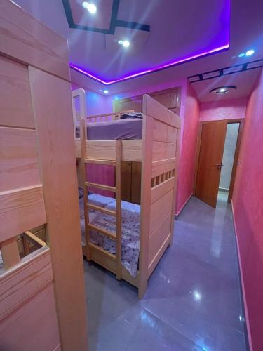 a room with two bunk beds with purple lights at Al Hoceima Hay Bades Villa in Al Hoceïma